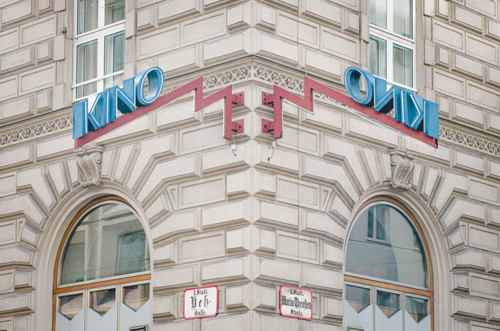 A mirrored double sign hanging from an ancient brick building